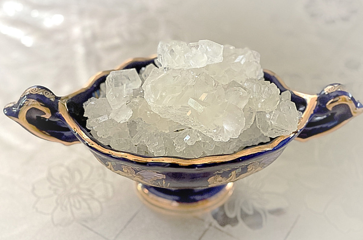 Blue and gold ceramic bowl filled with clear nabat crystals